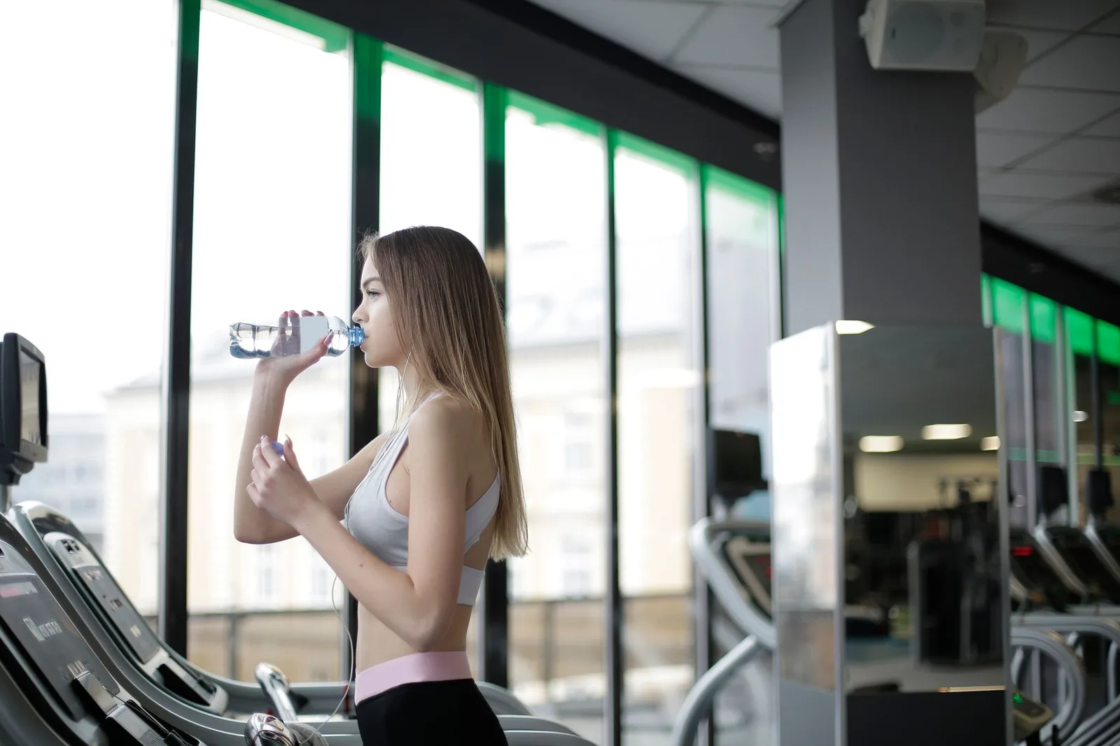 Asian woman drinking water after exercise — Photo: Andrea Piacquadio / Pexels
