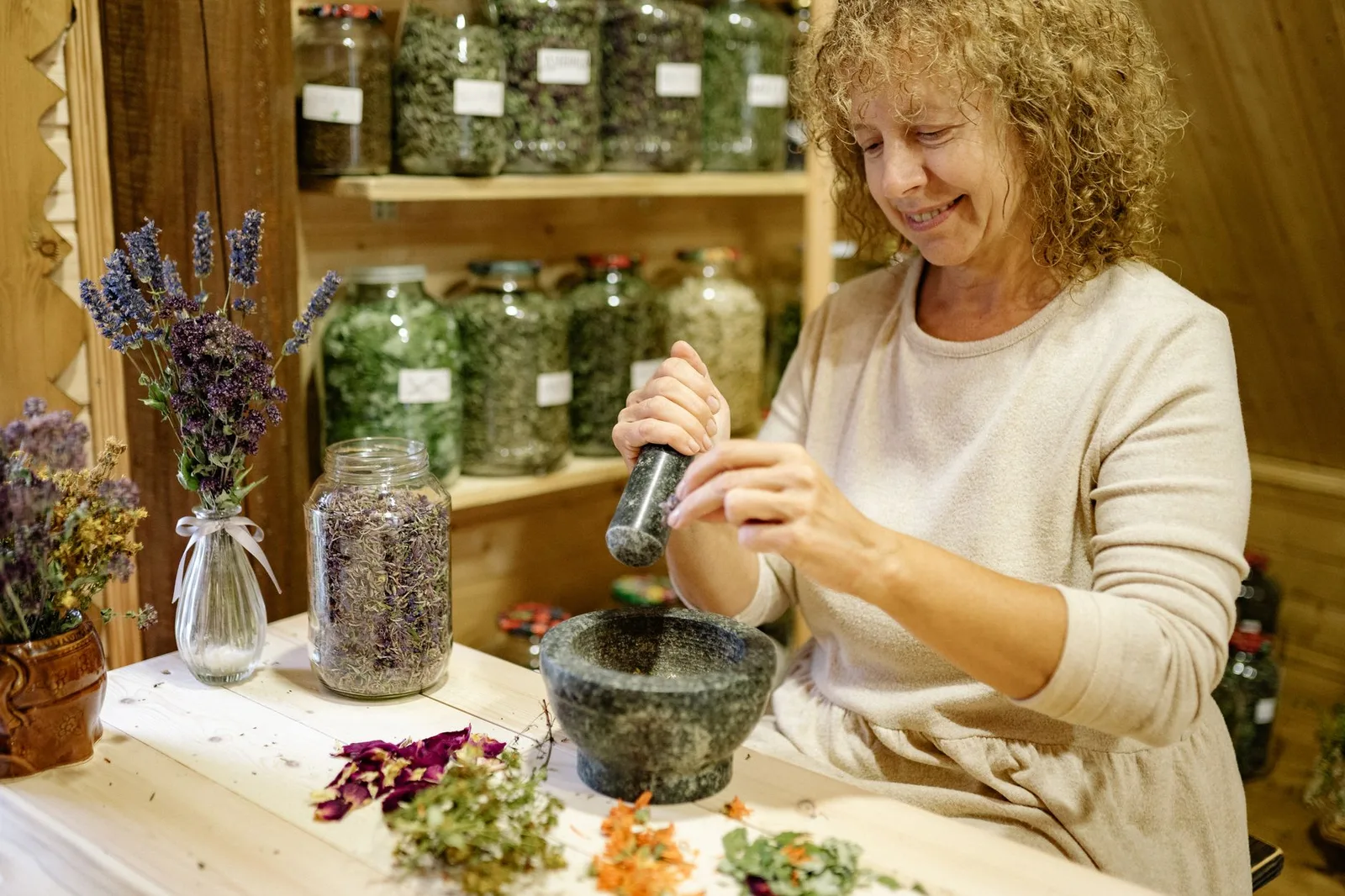 Asian woman choosing dried herbs — Photo: Yan Krukau / Pexels